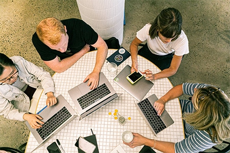 group of people at table on laptops