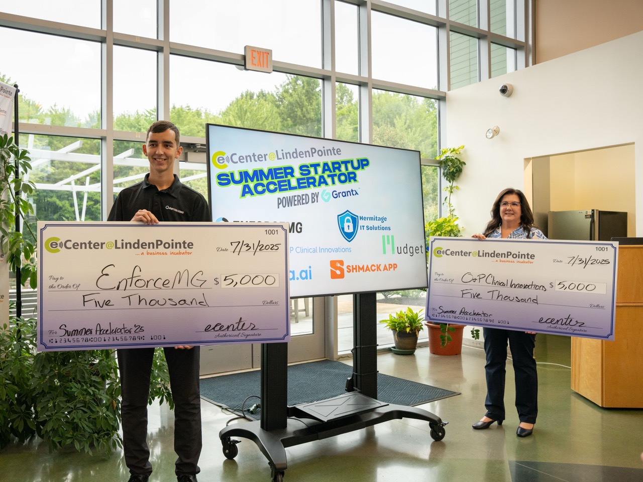 Winners holding large checks in eCenter lobby
