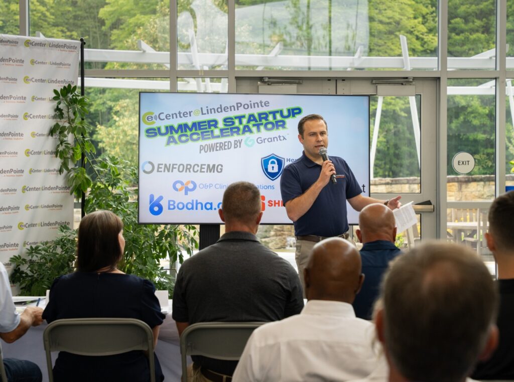 Judge speaking in microphone at Summer Startup Accelerator competition